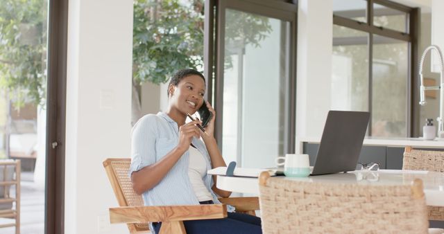 Smiling Woman Working Remotely on Phone Call in Bright Kitchen - Download Free Stock Images Pikwizard.com