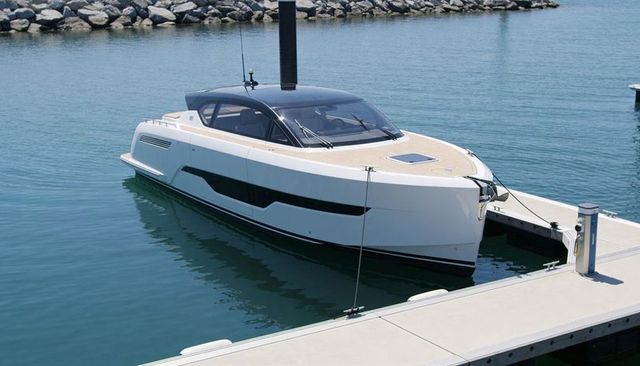 Luxury white motor yacht floating at marina with sleek tinted cabin and teak foredeck
