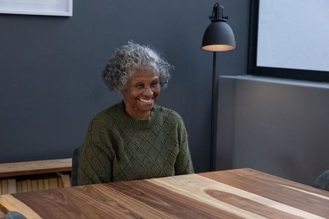Senior Woman Smiling Indoors Adding Comfort and Warmth