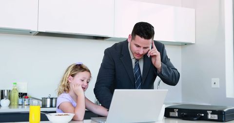 Father Multitasking in Kitchen with Daughter