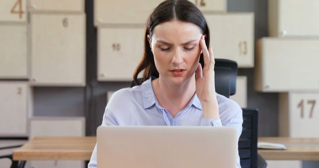 Stressed Woman Experiencing Headache While Working on Laptop in Modern Office - Download Free Stock Images Pikwizard.com