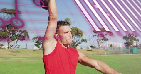 Male athlete throwing overhead on sunny park field during training session