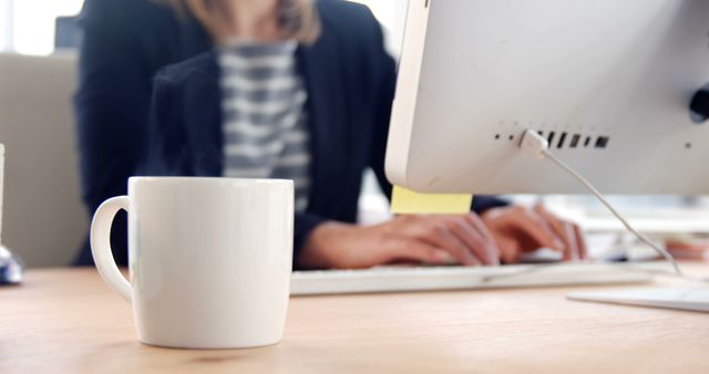 Businessperson Working on Computer with Coffee Mug in Office - Download Free Stock Images Pikwizard.com