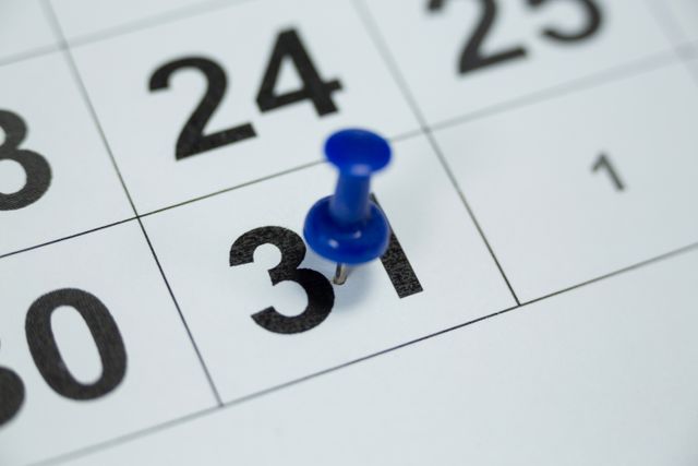 Close-up of a blue push pin marking the 31st day on a white calendar. Ideal for illustrating concepts related to planning, scheduling, reminders, and time management. Useful for blogs, articles, and presentations about organization and productivity.