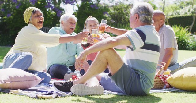 Senior friends toast to friendship and active living during a sunny garden picnic. - Download Free Stock Photos Pikwizard.com