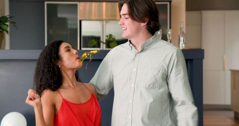 Happy Couple Celebrating Anniversary with Confetti Indoors