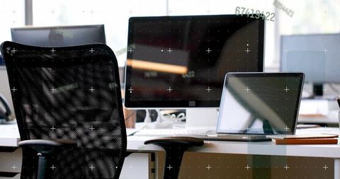 Modern ergonomic workstation with monitor and laptop showing digital data overlay