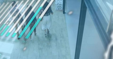 Three professionals walking under glass balustrade with turquoise graphic overlay in mall