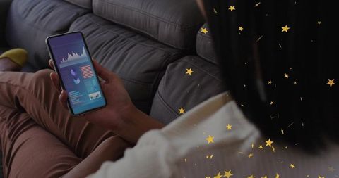 Woman checking finance app on smartphone with golden stars