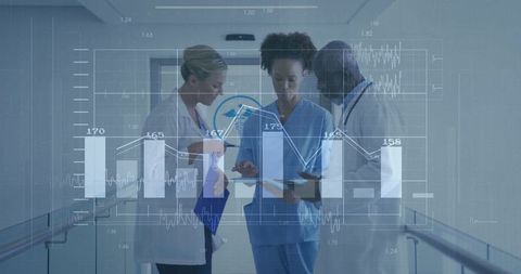 Medical team analyzing digital charts in hospital corridor