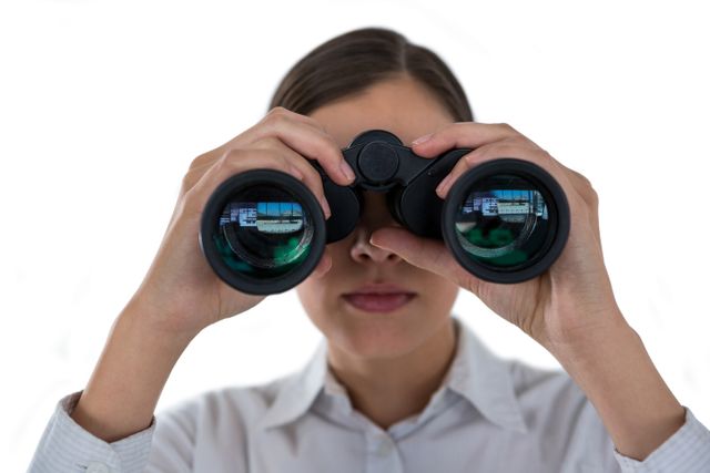 Close-up of businesswoman looking through binoculars against a white background