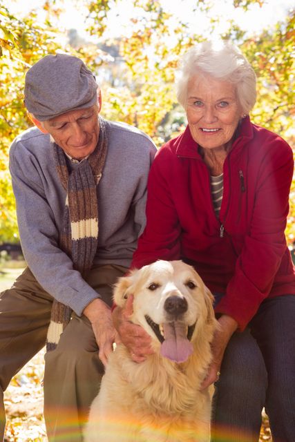 Portrait of elderly couple with their pet dog in the park