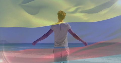 Man experiencing freedom at seaside with flag overlay