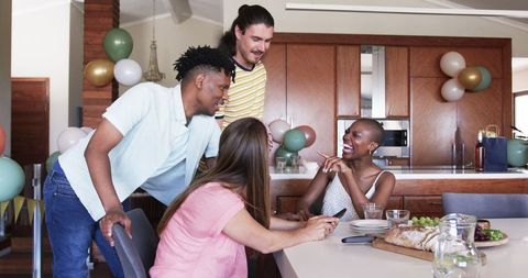 Happy Friends Enjoying Time Together in Modern Kitchen
