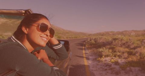 Young Woman Smiling Leaning Out of Car Window on Road Trip