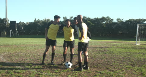 Soccer Team Strategizing on Field with Players Huddling Around Ball