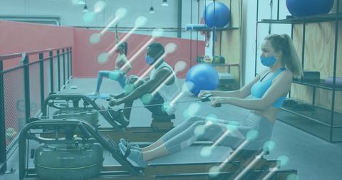 Masked Women Exercising on Rowing Machines in Gym - Download Free Stock Images Pikwizard.com