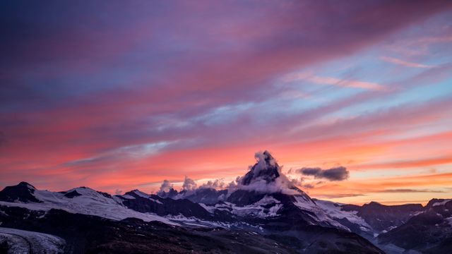 Capturing a stunning, colorful sunset over snow-capped mountain peaks. Ideal for travel guides, nature blogs, adventure tourism promotions, or motivational posters. Perfect for framing as wall art in homes, offices, or lodges to evoke a sense of peace and awe.