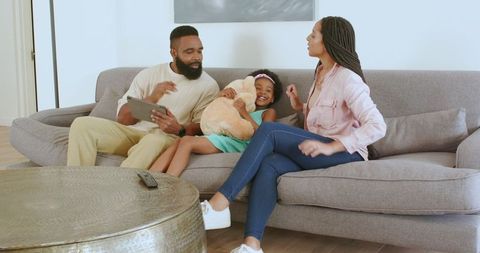 Family Bonding Moment on Sofa with Technology and Play