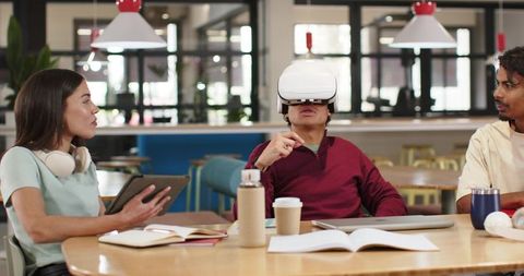 Collaborating with VR and Tablet in Modern Coworking Space, Diverse Team Testing Tech