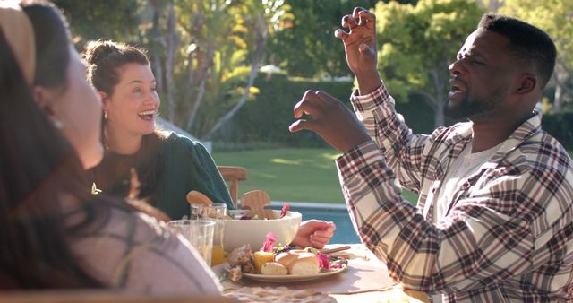 Friends sharing joyful moments while dining outdoors - Download Free Stock Images Pikwizard.com