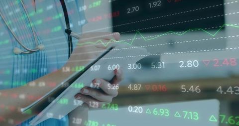 Nurse holding tablet and writing with stethoscope overlaying financial market data