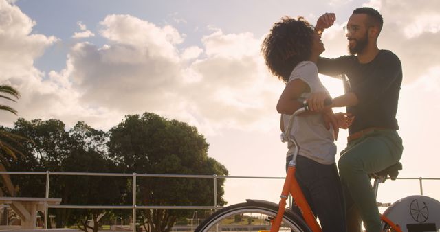 Romantic diverse couple with bike embracing and laughing on sunny beach, copy space - Download Free Stock Photos Pikwizard.com