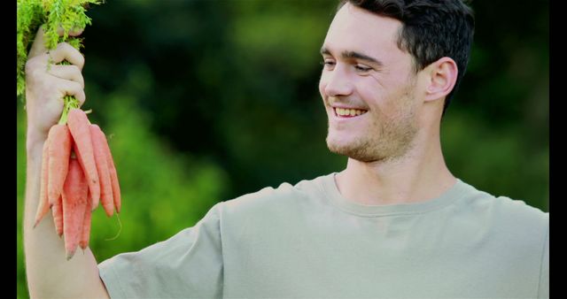 Smiling Farmer Holding Freshly Harvested Carrots Outdoors - Download Free Stock Images Pikwizard.com