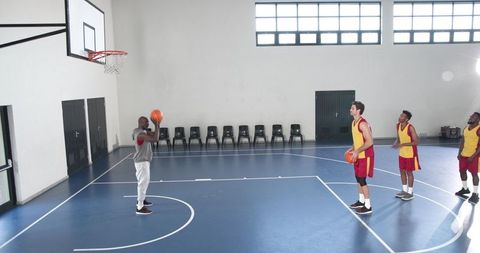 Basketball players practicing free throw technique on indoor court