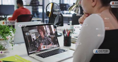 Woman Analyzing Data on Laptop in Modern Open Office