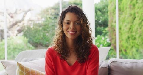 Smiling Biracial Woman Seated on Modern Sofa