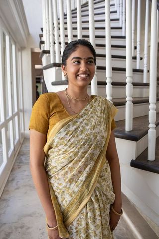 Elegant indian woman in traditional sari standing in luxurious interior