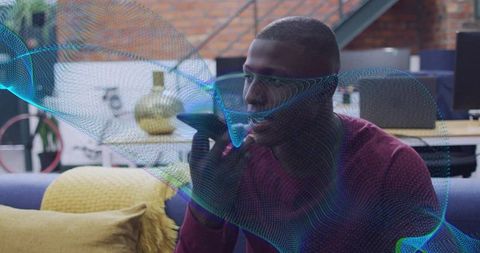 Man holding smartphone on sofa speaking to voice assistant with holographic data wave