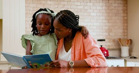 Mother and Daughter Reading Together in Cozy Kitchen