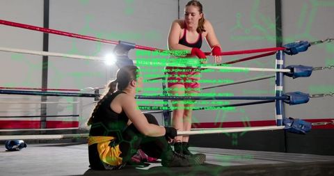 Resting female boxers in corner between rounds with green hud data overlay