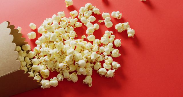 Tasty Popcorn Spilling on Vibrant Red Background - Download Free Stock Images Pikwizard.com