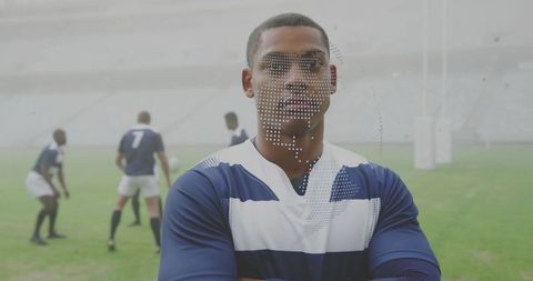 Confident rugby captain standing arms crossed on misty stadium pitch