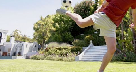 Young Man Practicing Soccer Skills Outdoors in Sunny Garden