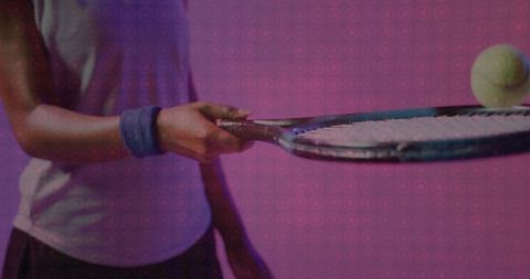 Female tennis player balancing ball mid-motion indoor studio