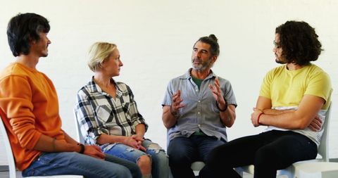 Diverse adults engaged in discussion at a support group meeting