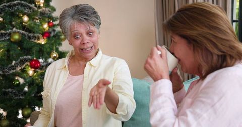 Mother and Daughter Sharing Stories by Christmas Tree