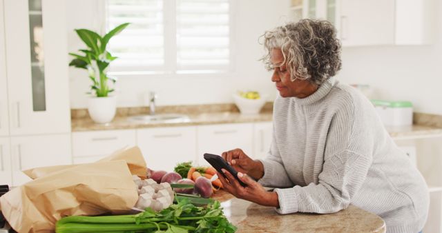 Senior Woman Using Smartphone in Healthy Kitchen - Download Free Stock Images Pikwizard.com