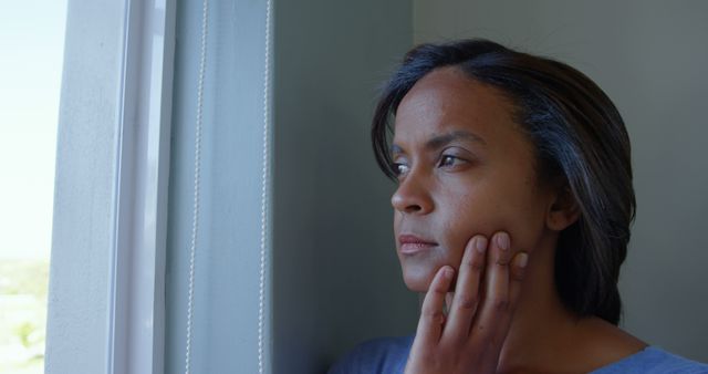 Pensive Woman Looking Out Window with Hand on Face - Download Free Stock Images Pikwizard.com