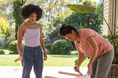 Mother and Daughter Painting Together on Porch Outdoors