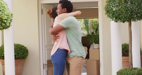 Happy couple embracing outside new home celebrating ownership
