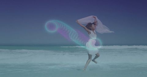 Joyful woman dancing on ocean shore with neon spiral effect