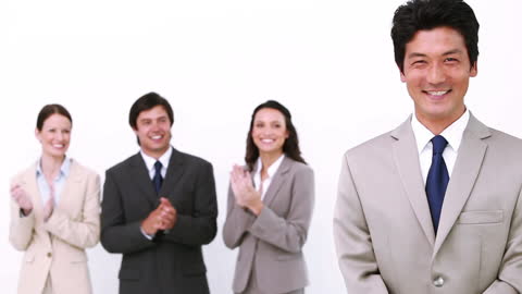 Smiling Businessman Being Congratulated by Coworkers