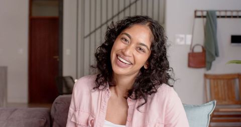 Cheerful Woman Relaxing in Cozy Modern Living Room with Staircase