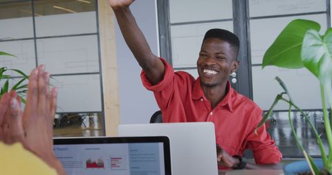 Cheerful african american businessman high-fives colleague