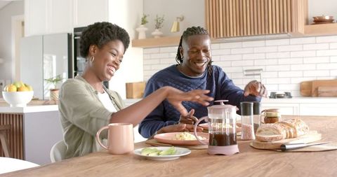 Happy African American Couple Enjoying Breakfast Together in Cozy Modern Kitchen